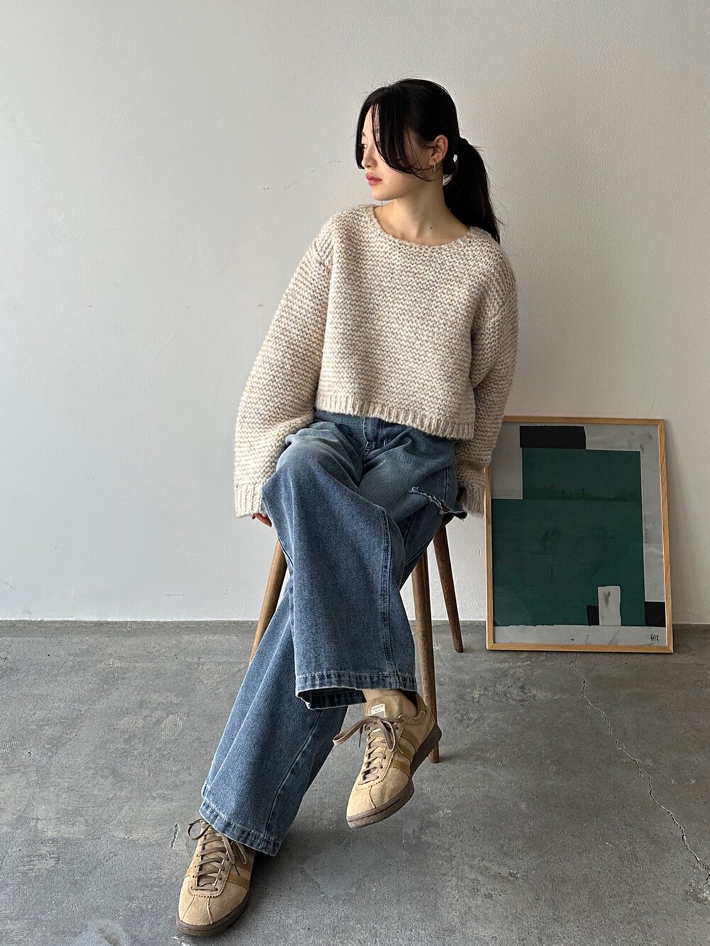 ホワイト系のニット/セーター、ブルー系のデニムパンツ、ベージュ系のスニーカーを着用したレディースの冬コーディネートの3枚目の写真