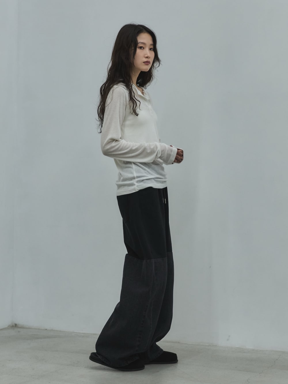 ホワイト系のキャミソール、ホワイト系のTシャツ/カットソー、ブラック系のデニムパンツを着用したレディースの秋コーディネートの4枚目の写真