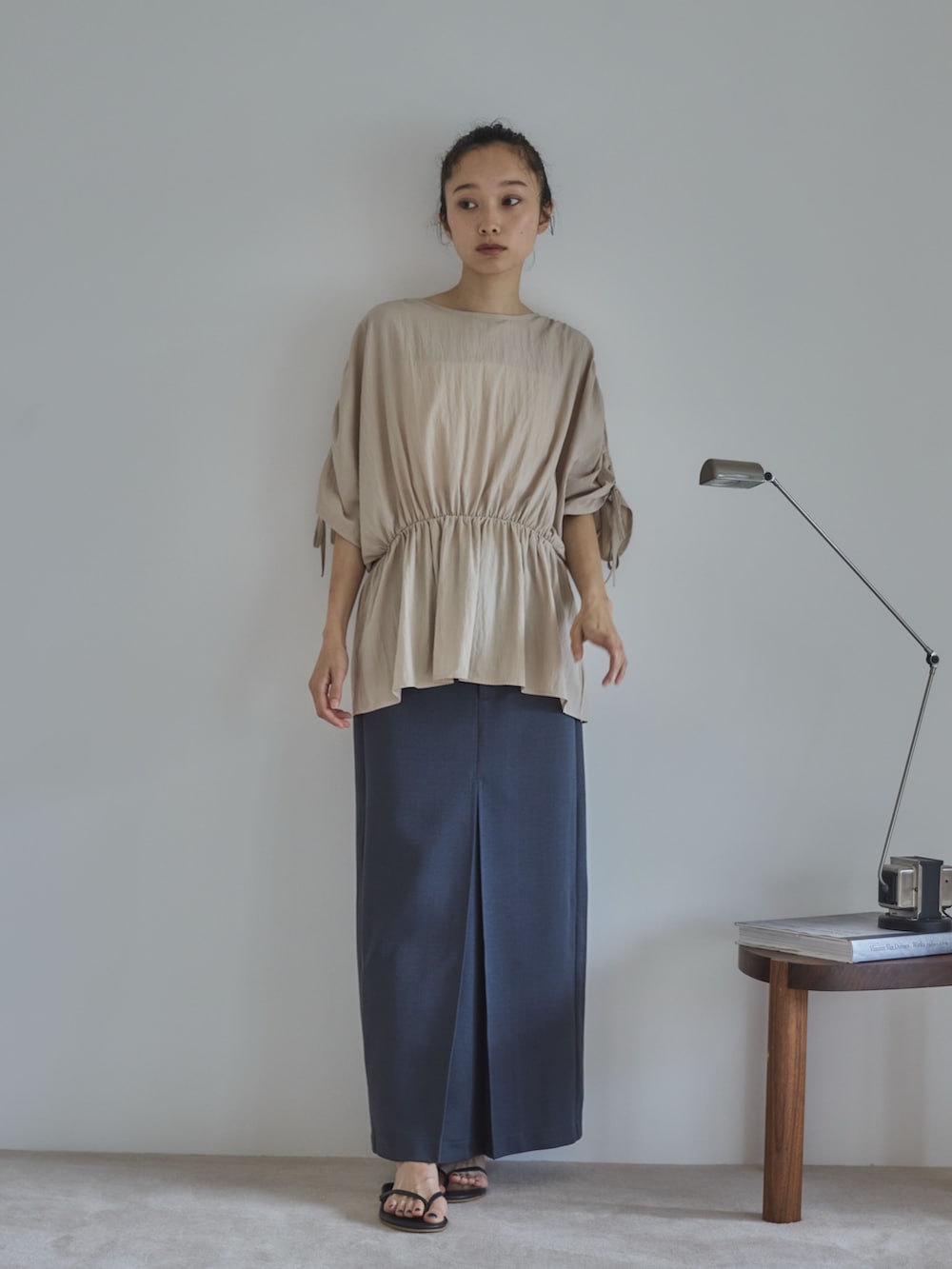 ホワイト系のシャツ/ブラウス、グレー系のスカート、ブラック系のサンダルを着用したレディースの夏コーディネートの2枚目の写真