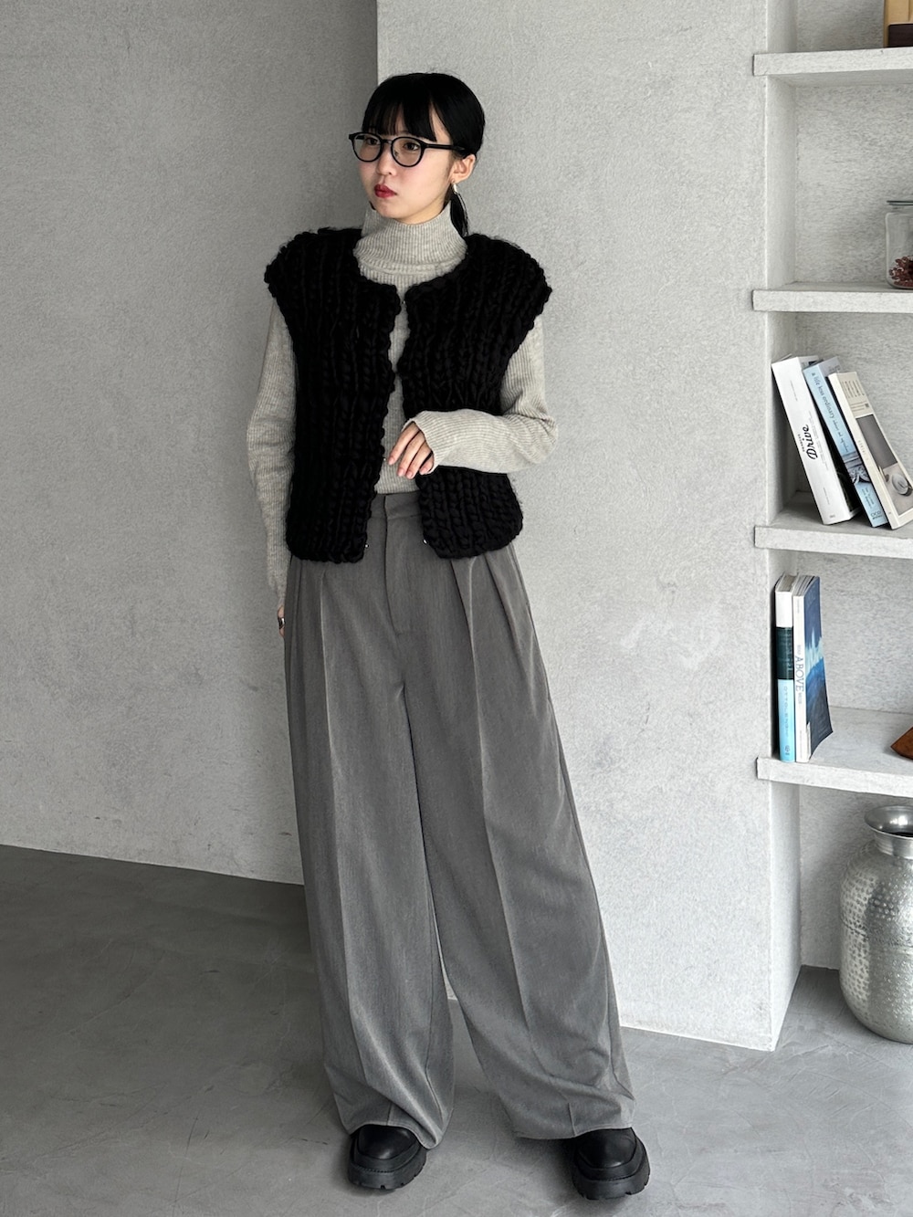 グレー系のニット/セーター、ブラック系のベスト、グレー系のスラックスを着用したレディースの冬コーディネートの2枚目の写真