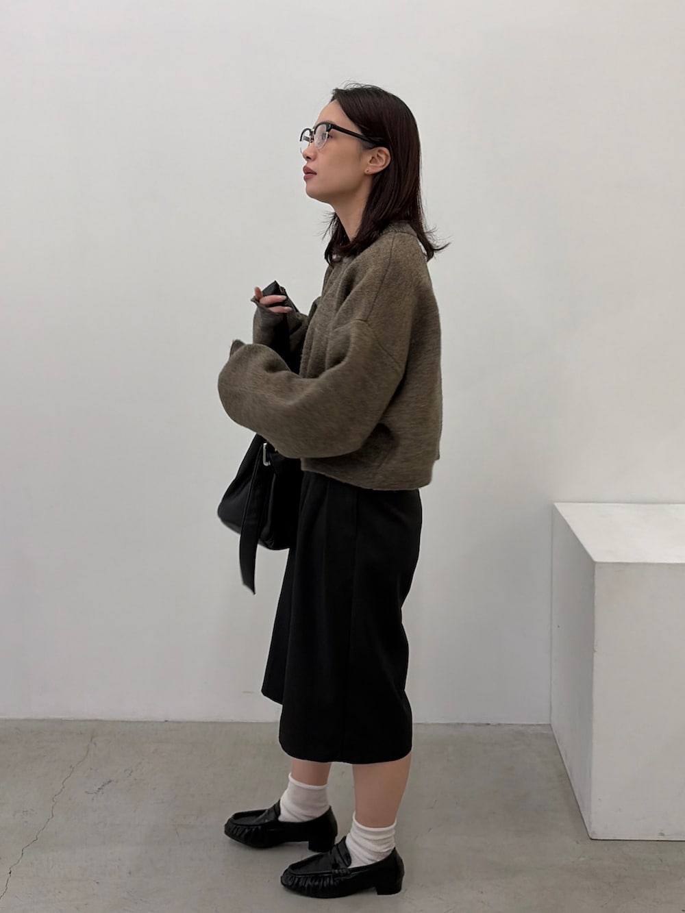 ブラウン系のニット/セーター、ブラック系のその他パンツ、ブラック系のローファーを着用したレディースの秋コーディネートの2枚目の写真