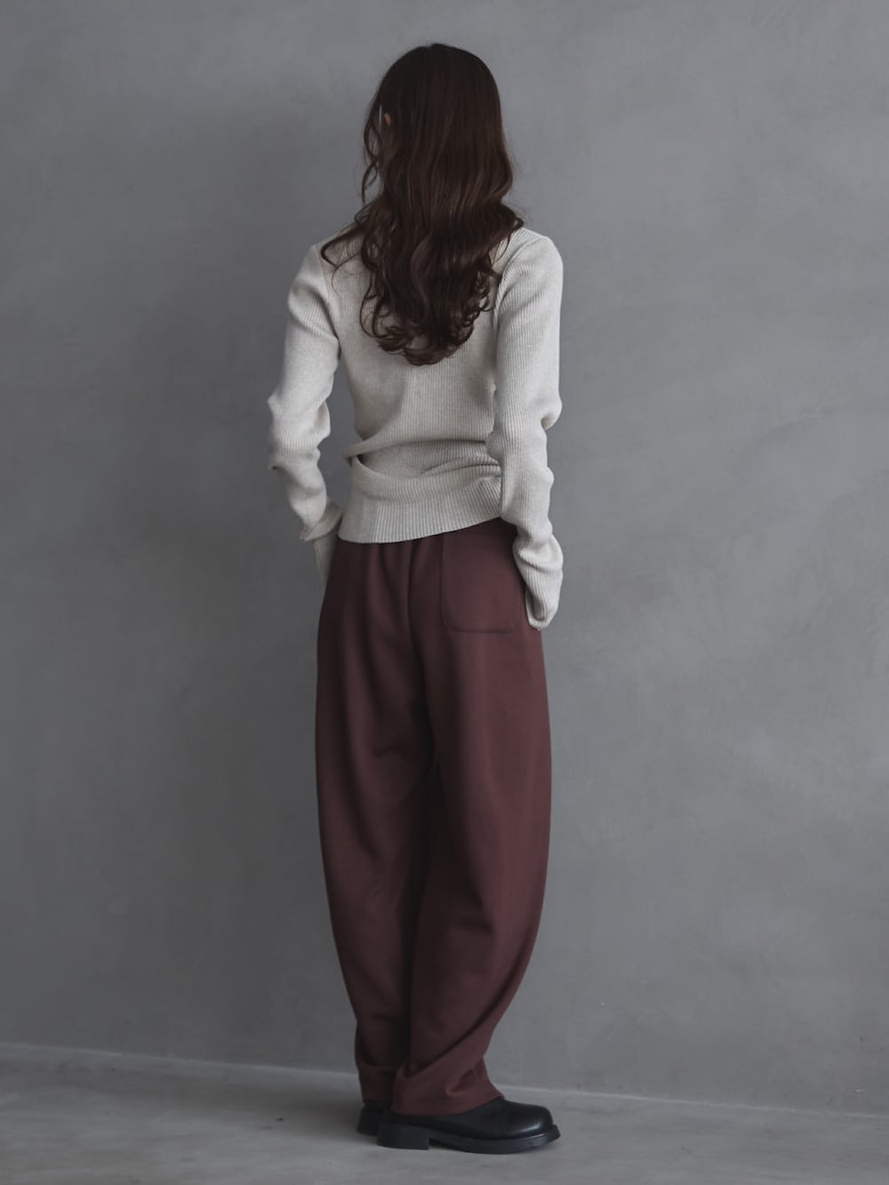 ホワイト系のニット/セーター、ブラウン系のその他パンツ、ブラック系のその他シューズを着用したレディースの冬コーディネートの4枚目の写真