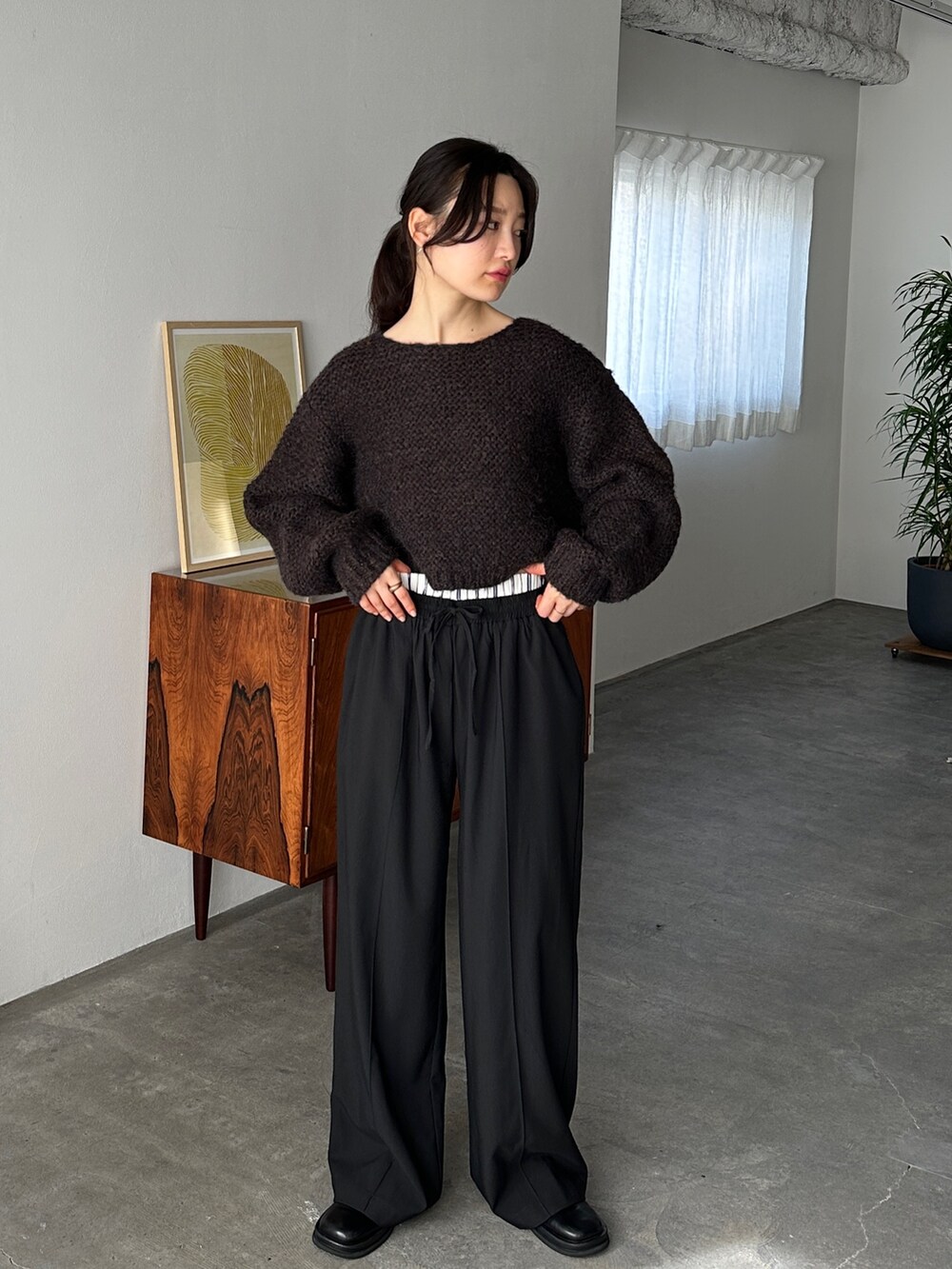 ブラウン系のニット/セーター、ブラック系のスラックス、ブラック系のスリッポンを着用したレディースの冬コーディネートの2枚目の写真