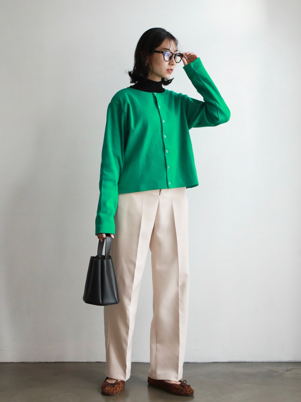 グリーン系のカーディガン/ボレロ、ベージュ系のその他パンツ、ホワイト系のトートバッグを着用したレディースの冬コーディネートの2枚目の写真
