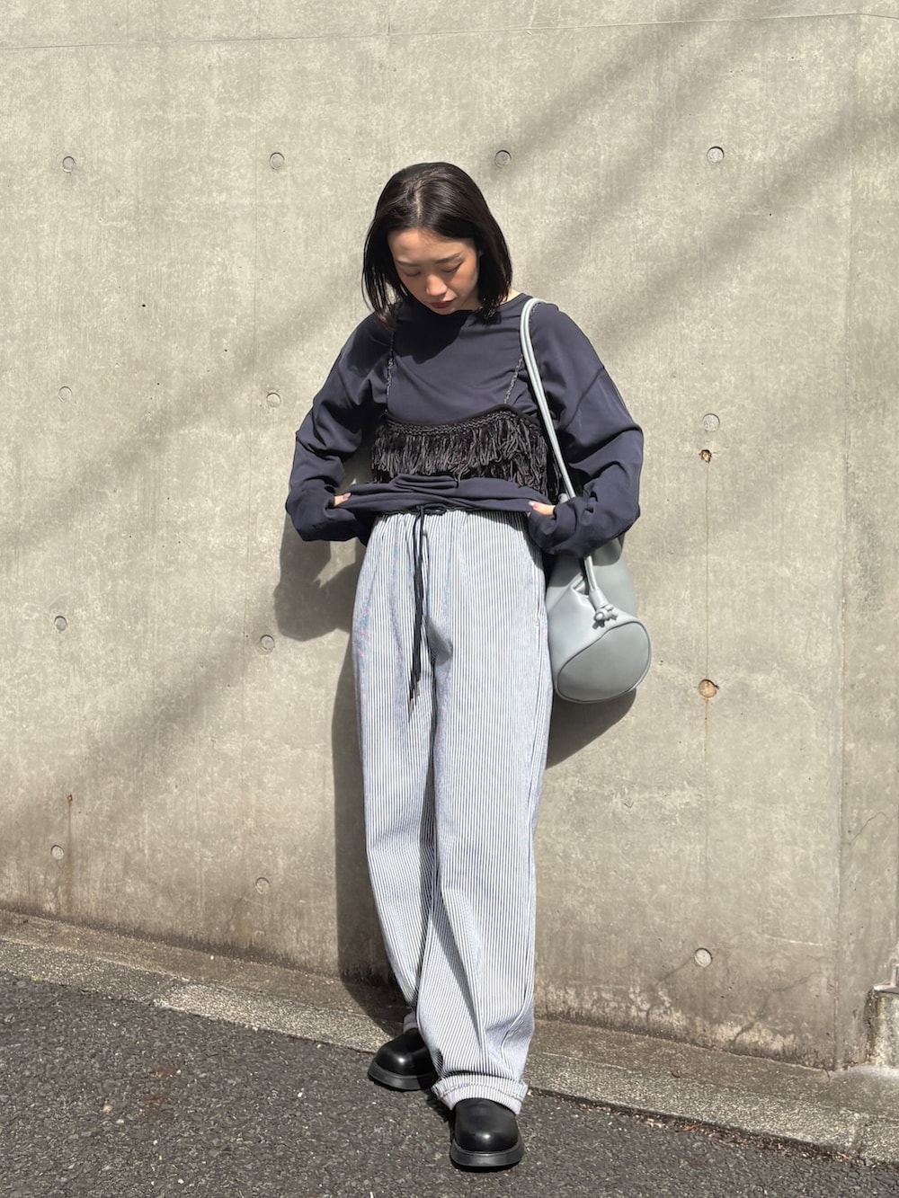 ホワイト系のデニムパンツ、ブラック系のその他シューズ、ブルー系のTシャツ/カットソーを着用したレディースの春コーディネートの2枚目の写真