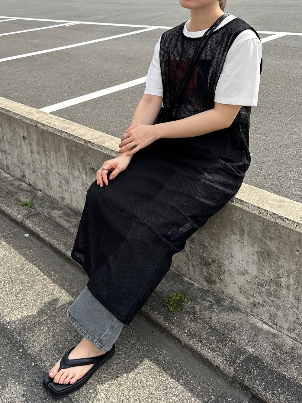 ブラック系のワンピース、グレー系のデニムパンツ、ブラック系のショルダーバッグを着用したレディースの夏コーディネートの3枚目の写真
