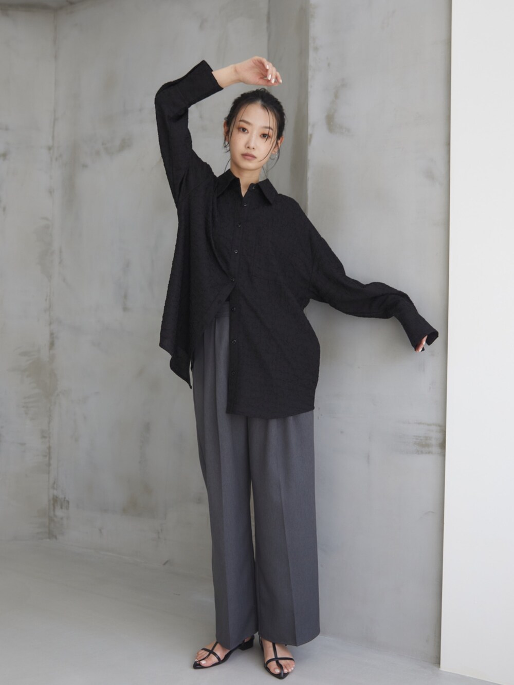 ブラック系のシャツ/ブラウス、グレー系のスラックス、ブラック系のサンダルを着用したレディースの夏コーディネートの3枚目の写真