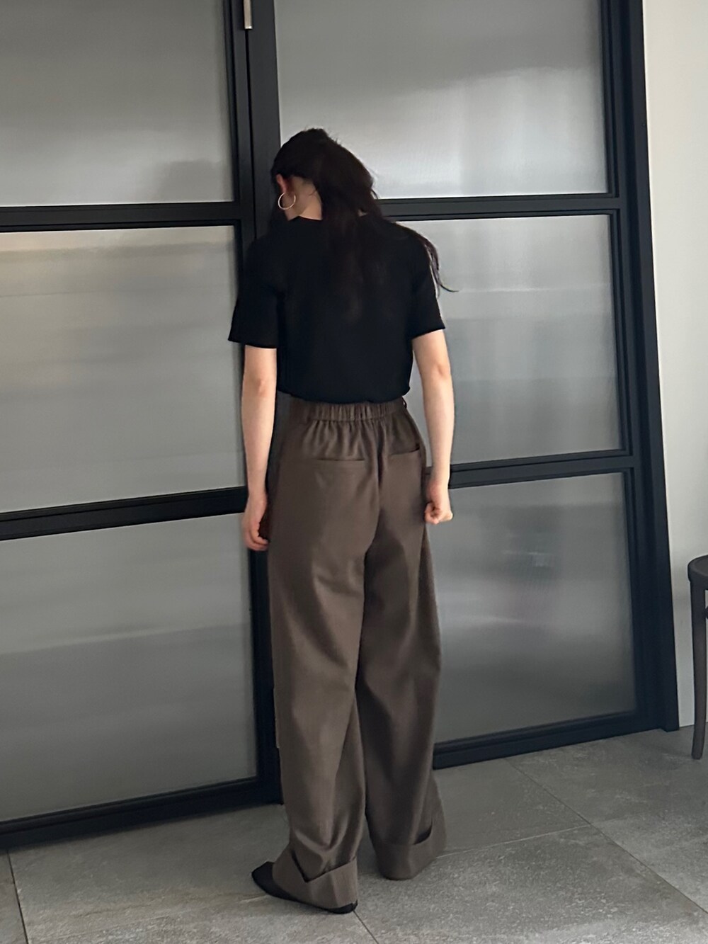 ブラック系のTシャツ/カットソー、ブラウン系のスラックス、ベージュ系のその他シューズを着用したレディースの春コーディネートの3枚目の写真