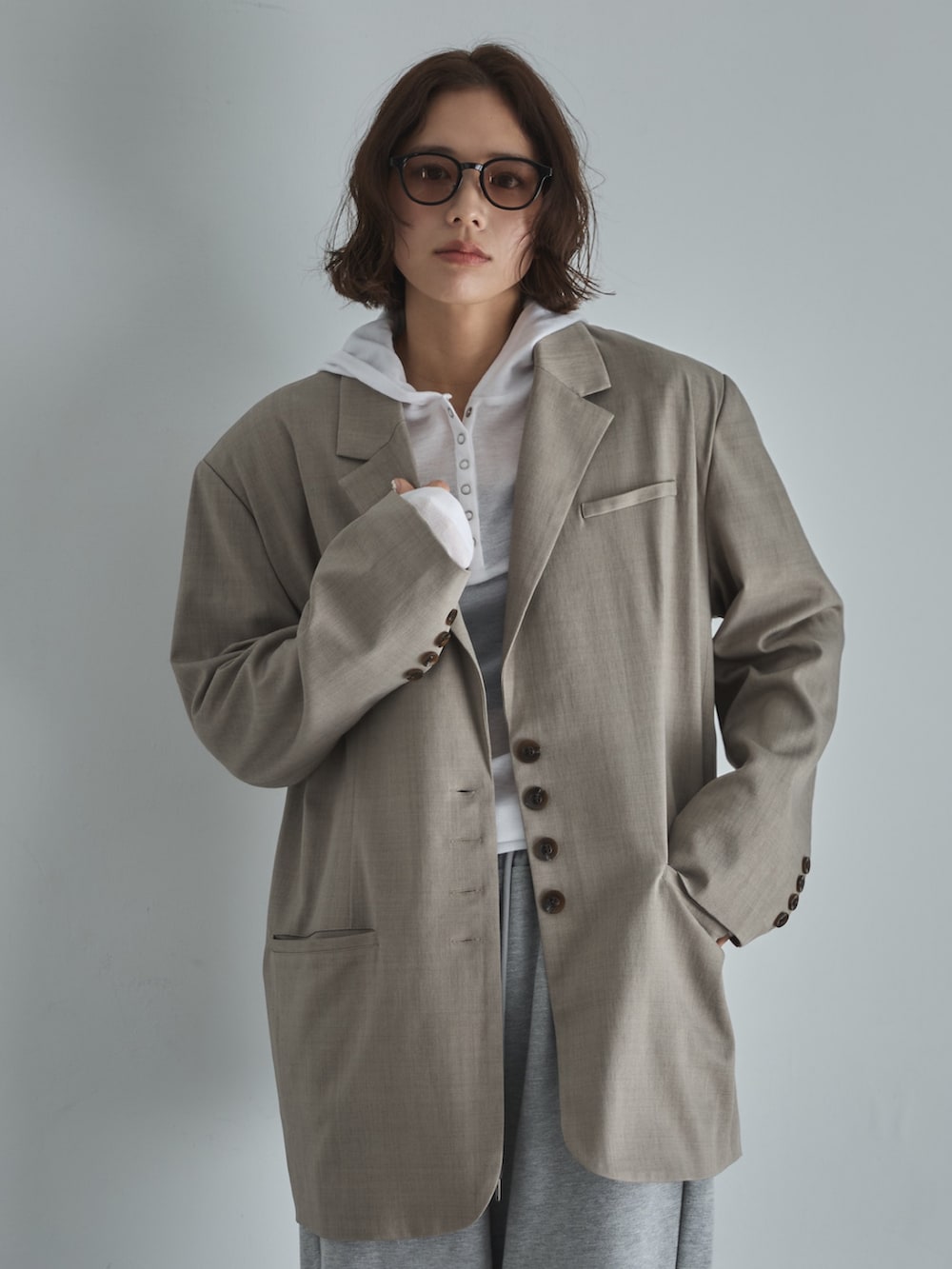 ベージュ系のテーラードジャケット、ホワイト系のTシャツ/カットソー、グレー系のスウェットパンツを着用したレディースの冬コーディネートの5枚目の写真