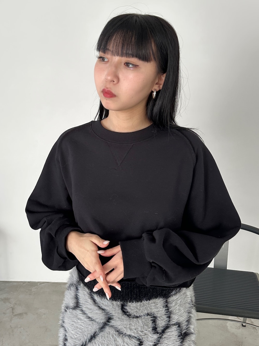 グレー系のスカート、ブラック系のブーツ、ブラック系のスウェットを着用したレディースの冬コーディネートの4枚目の写真