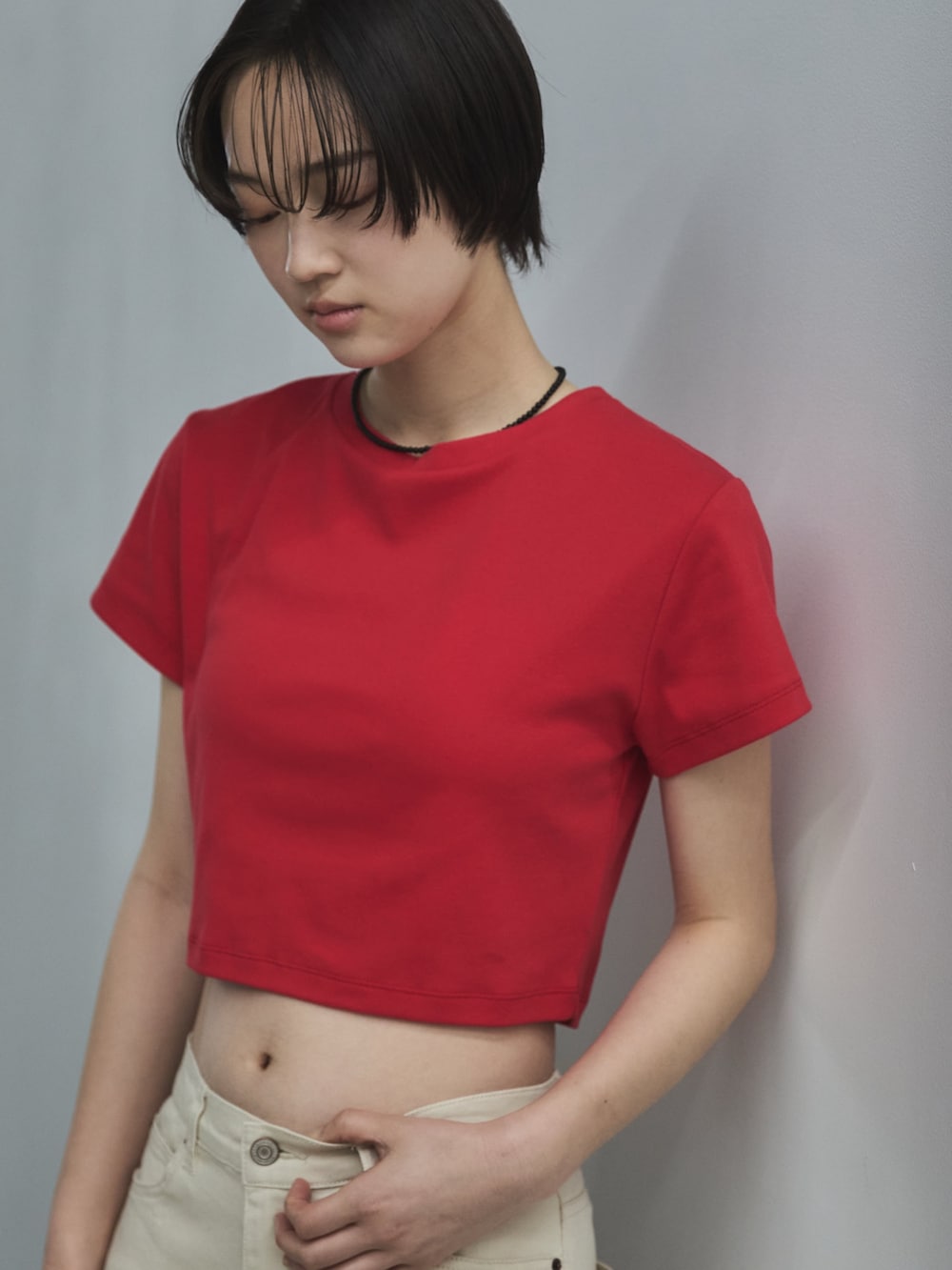 レッド系のTシャツ/カットソー、ホワイト系のデニムパンツ、ベージュ系のサンダルを着用したレディースの春コーディネートの7枚目の写真