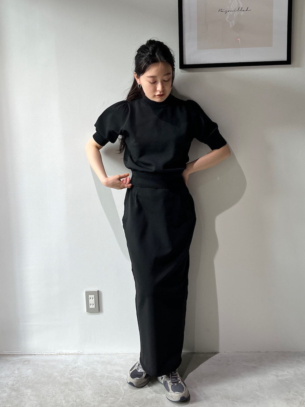 ブラック系のスカート、ブラック系のニット/セーター、グレー系のスニーカーを着用したレディースの春コーディネートの3枚目の写真