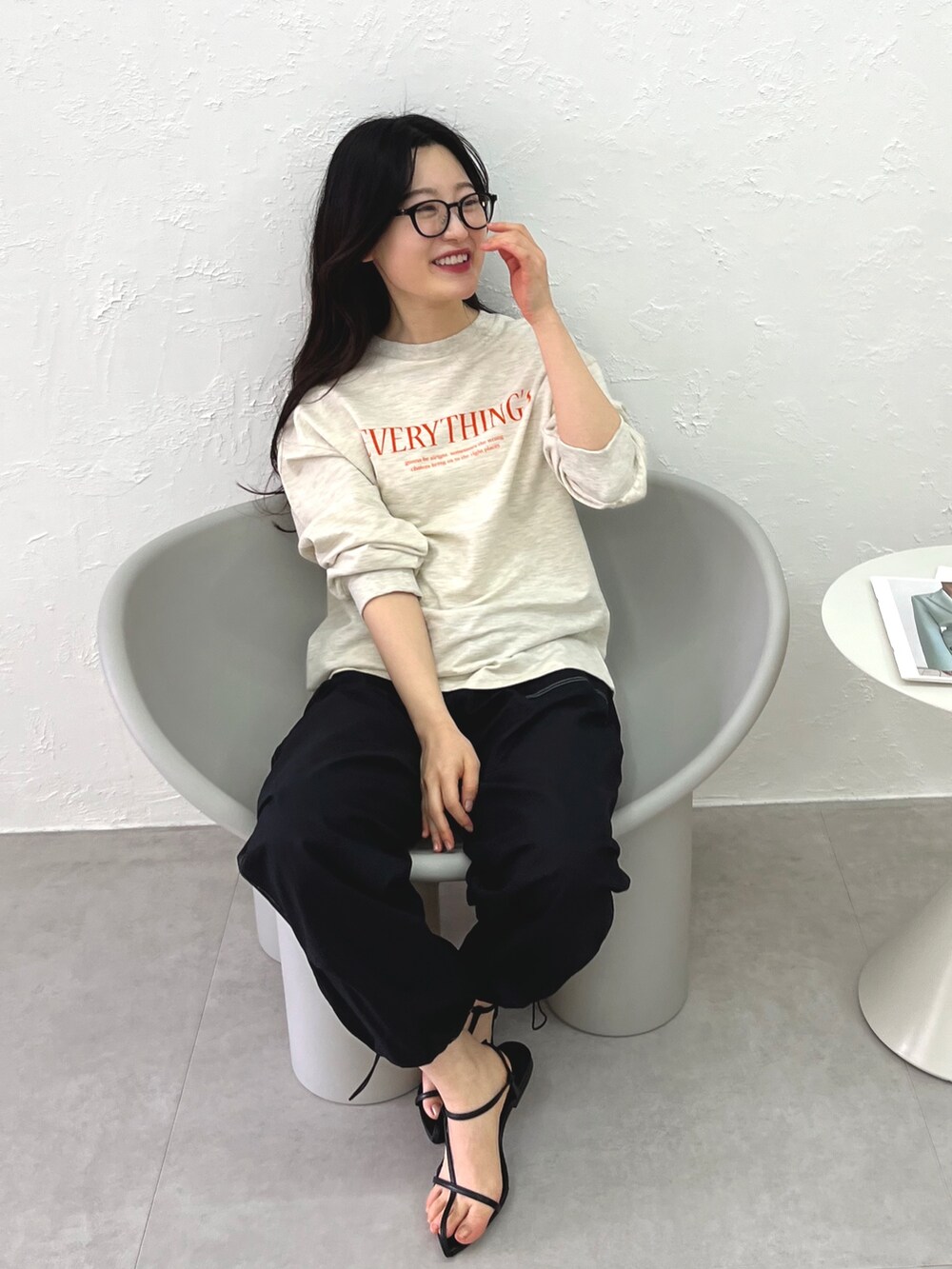 ブラック系のカーゴパンツ、ブラック系のサンダル、ベージュ系のスウェットを着用したレディースの冬コーディネートの3枚目の写真