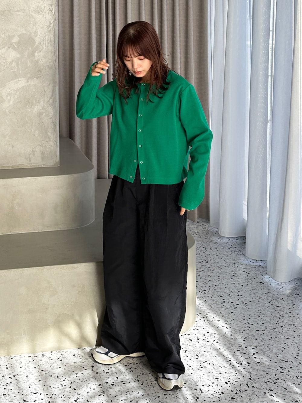 グリーン系のカーディガン/ボレロ、ホワイト系のスニーカー、ブラック系のカーゴパンツを着用したレディースの冬コーディネートの2枚目の写真