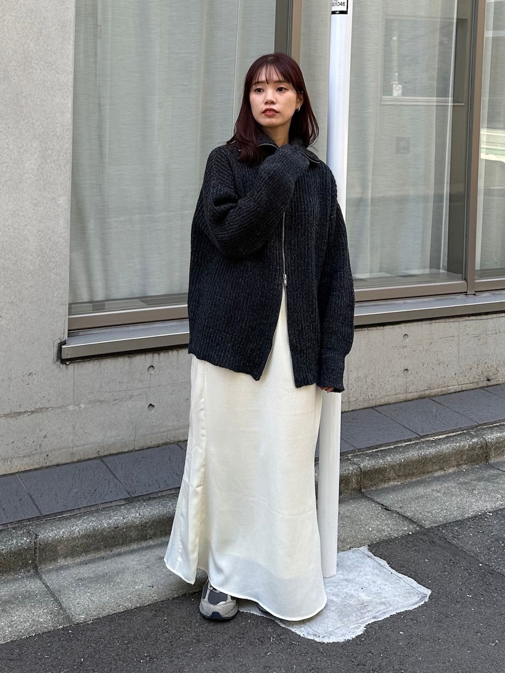 ブラック系のカーディガン/ボレロ、ホワイト系のスカート、グレー系のスニーカーを着用したレディースの冬コーディネートの2枚目の写真