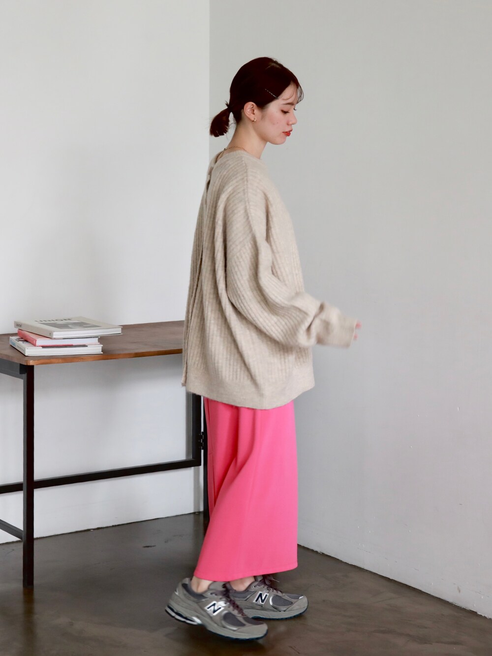 ブラック系のマウンテンパーカー、ブラック系のハンドバッグ、ピンク系のスカートを着用したレディースの秋コーディネートの4枚目の写真