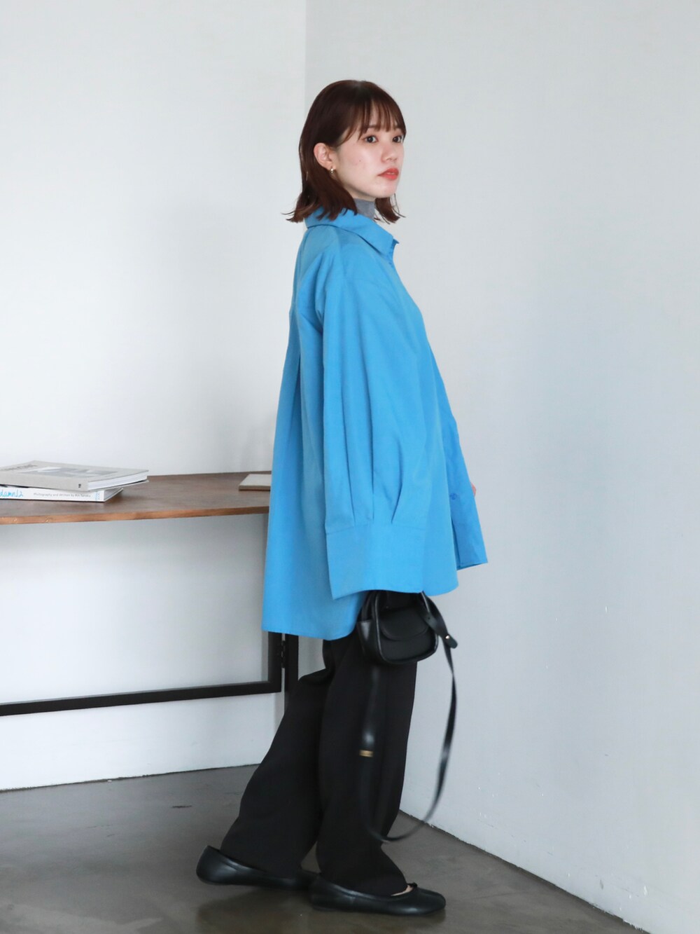 ブラック系のスラックス、ブラック系のパンプス、ブルー系のシャツ/ブラウスを着用したレディースの秋コーディネートの3枚目の写真