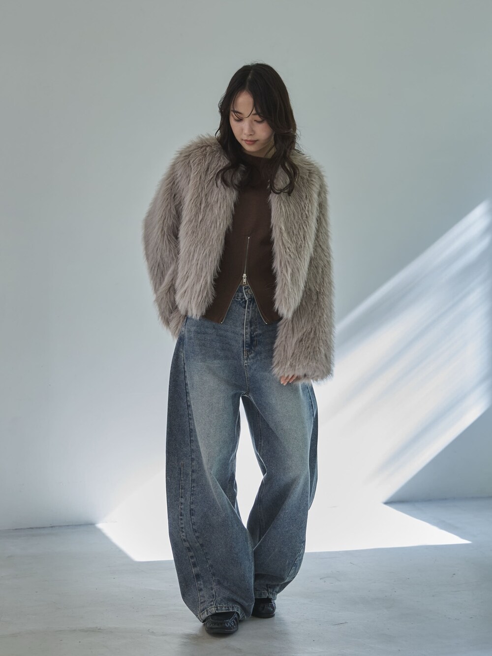 ベージュ系のその他アウター、ブラウン系のニット/セーター、ブルー系のデニムパンツを着用したレディースの冬コーディネートの2枚目の写真