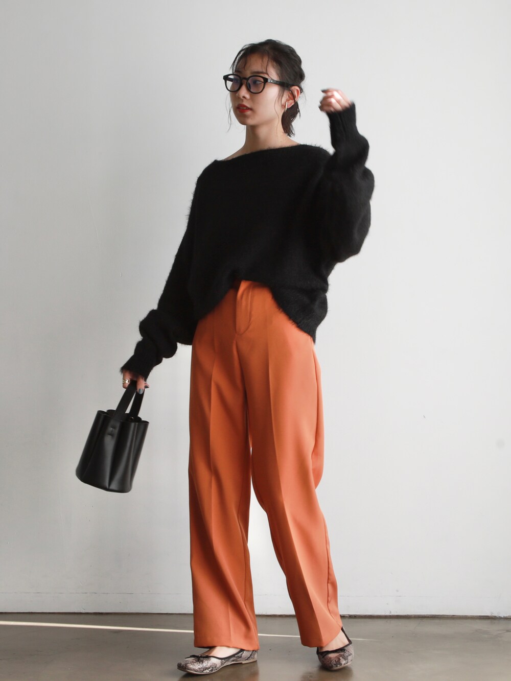 ブルー系のTシャツ/カットソー、ブラック系のハンドバッグ、ホワイト系のスニーカーを着用したレディースの冬コーディネートの5枚目の写真