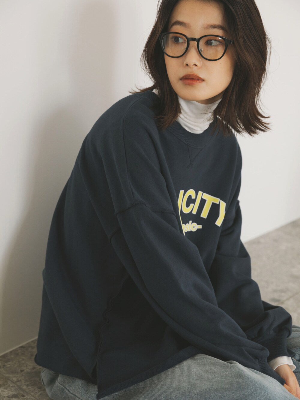 ブルー系のスウェット、ホワイト系のTシャツ/カットソー、ブルー系のデニムパンツを着用したレディースの秋コーディネートの3枚目の写真