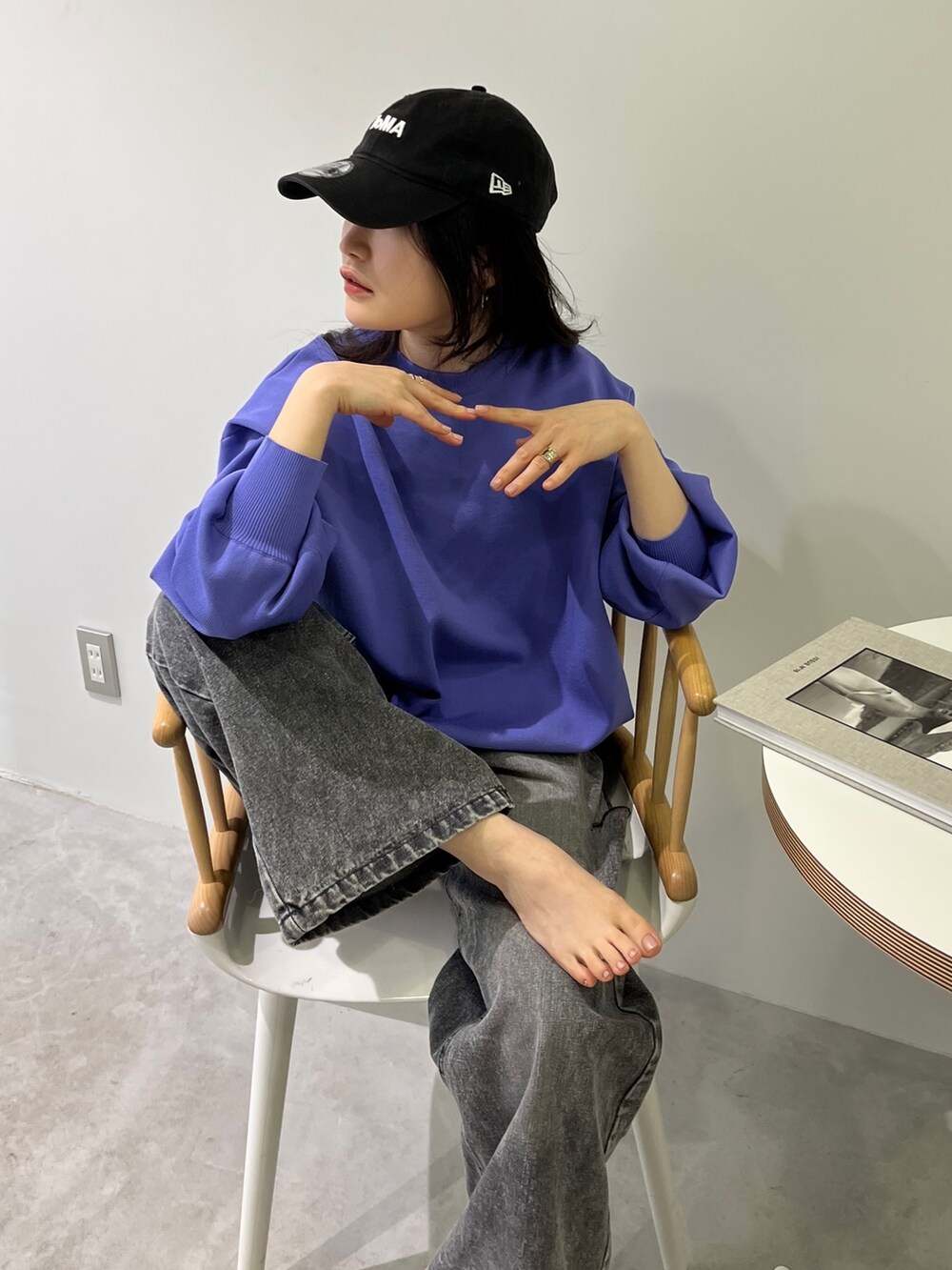 パープル系のカーディガン/ボレロ、ブラック系のデニムパンツ、グレー系のスニーカーを着用したレディースの冬コーディネートの2枚目の写真