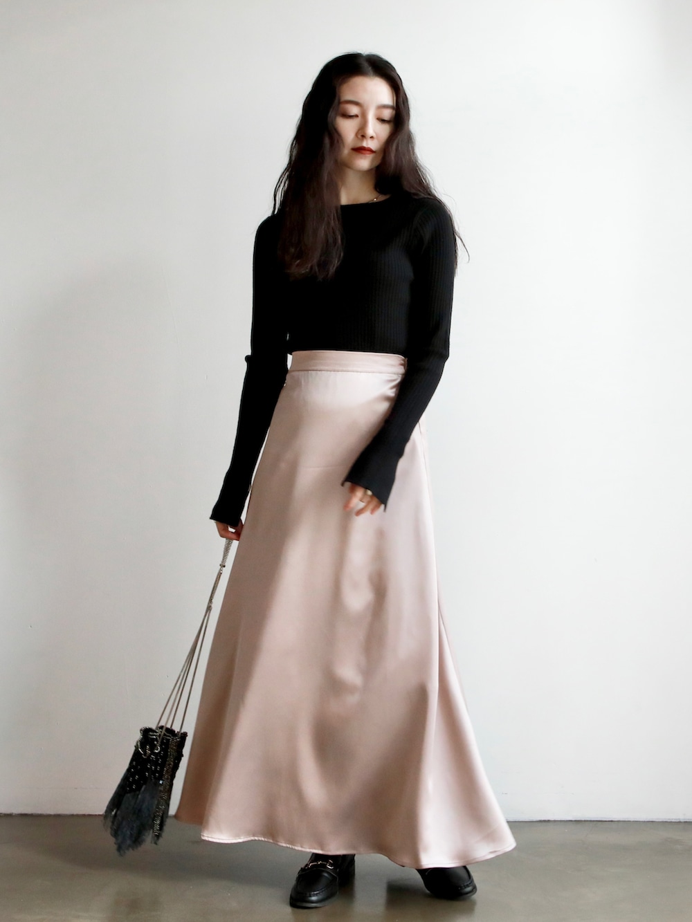 ホワイト系のニット/セーター、ブラック系のその他パンツ、ブラック系のハンドバッグを着用したレディースの冬コーディネートの2枚目の写真