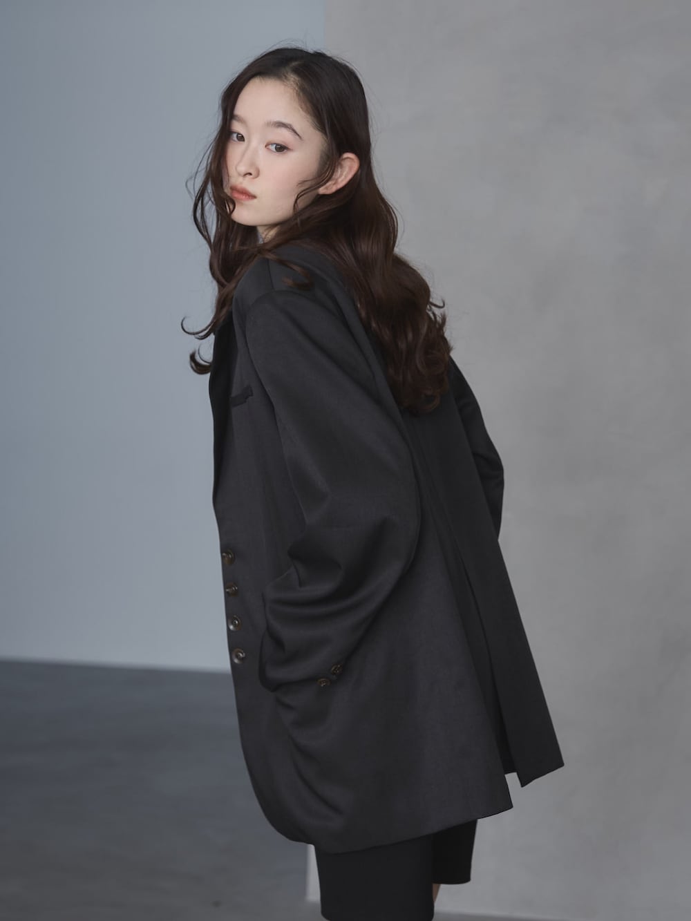 ブラック系のテーラードジャケット、ホワイト系のTシャツ/カットソー、ブラック系のその他パンツを着用したレディースの春コーディネートの5枚目の写真