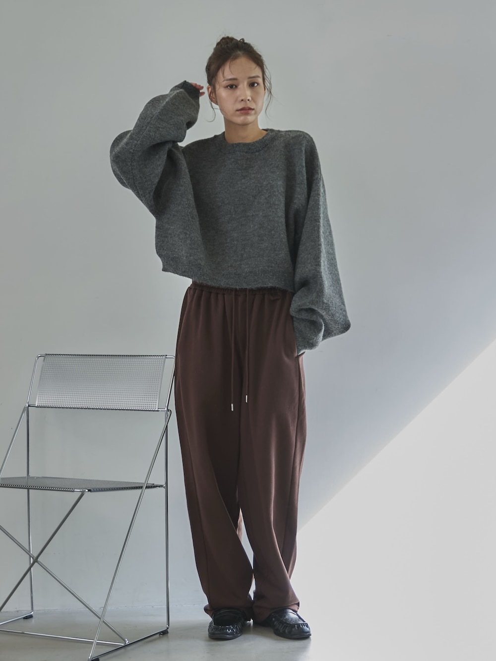 グレー系のニット/セーター、ブラウン系のその他パンツ、ブラック系のローファーを着用したレディースの冬コーディネートの2枚目の写真