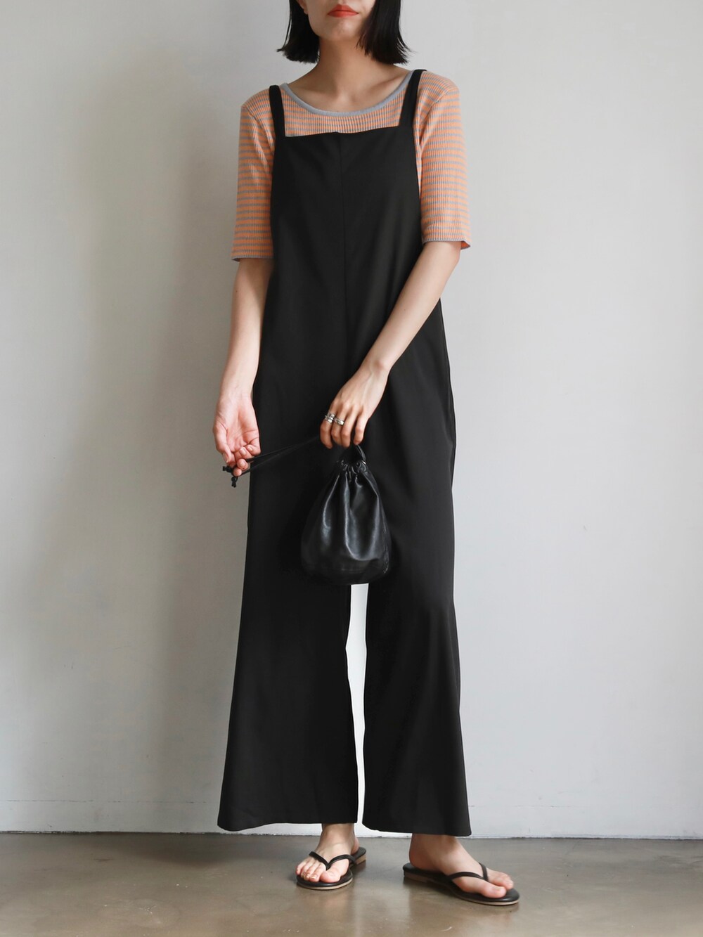 ブラック系のサロペット/オーバーオール、ブラック系のハンドバッグ、グレー系のTシャツ/カットソーを着用したレディースの夏コーディネートの3枚目の写真