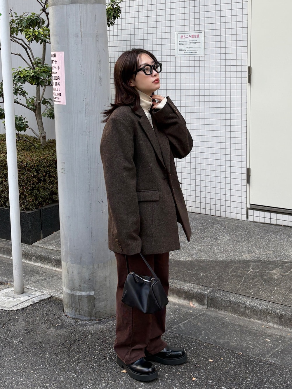 ブラウン系のテーラードジャケット、ブラック系のショルダーバッグ、ブラウン系のその他パンツを着用したレディースの冬コーディネートの6枚目の写真