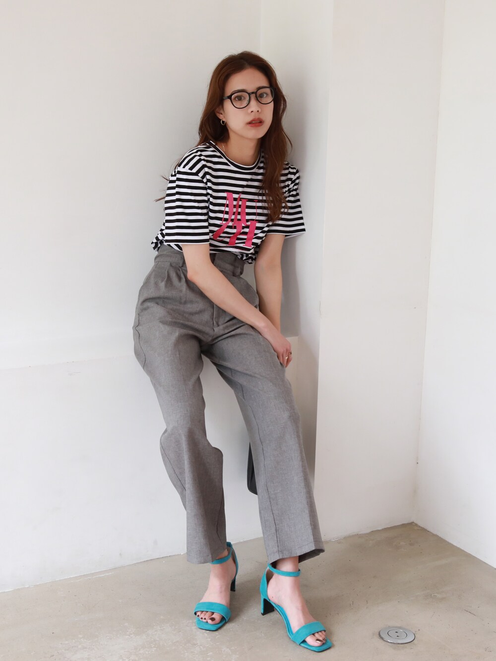 ブルー系のサンダル、ブラック系のショルダーバッグ、グレー系のスラックスを着用したレディースの夏コーディネートの3枚目の写真