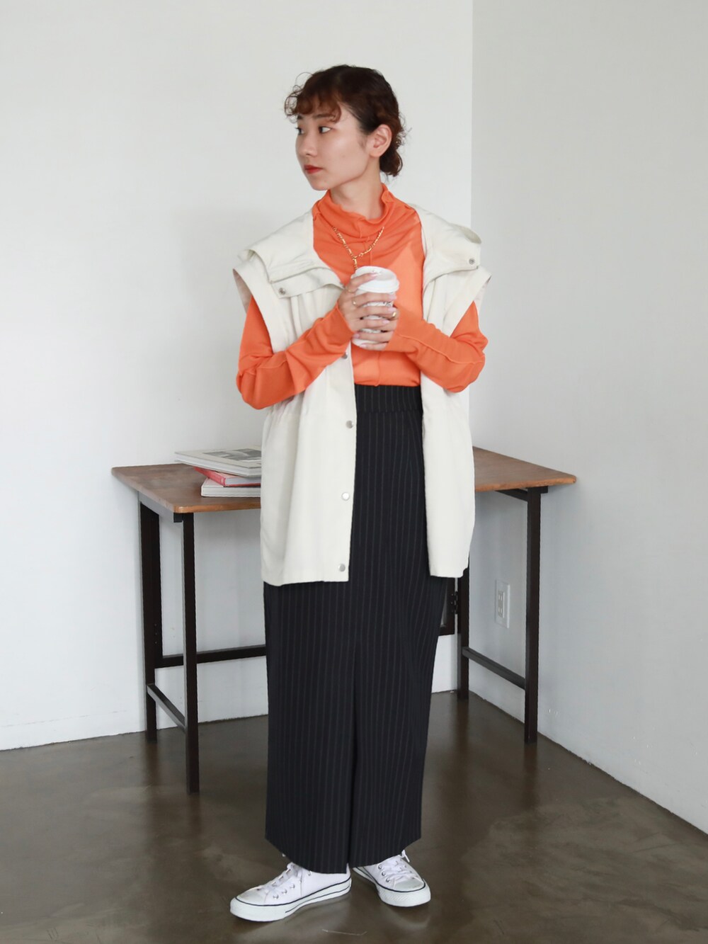 ホワイト系のスニーカー、ブルー系のスカート、オレンジ系のTシャツ/カットソーを着用したレディースの秋コーディネートの2枚目の写真