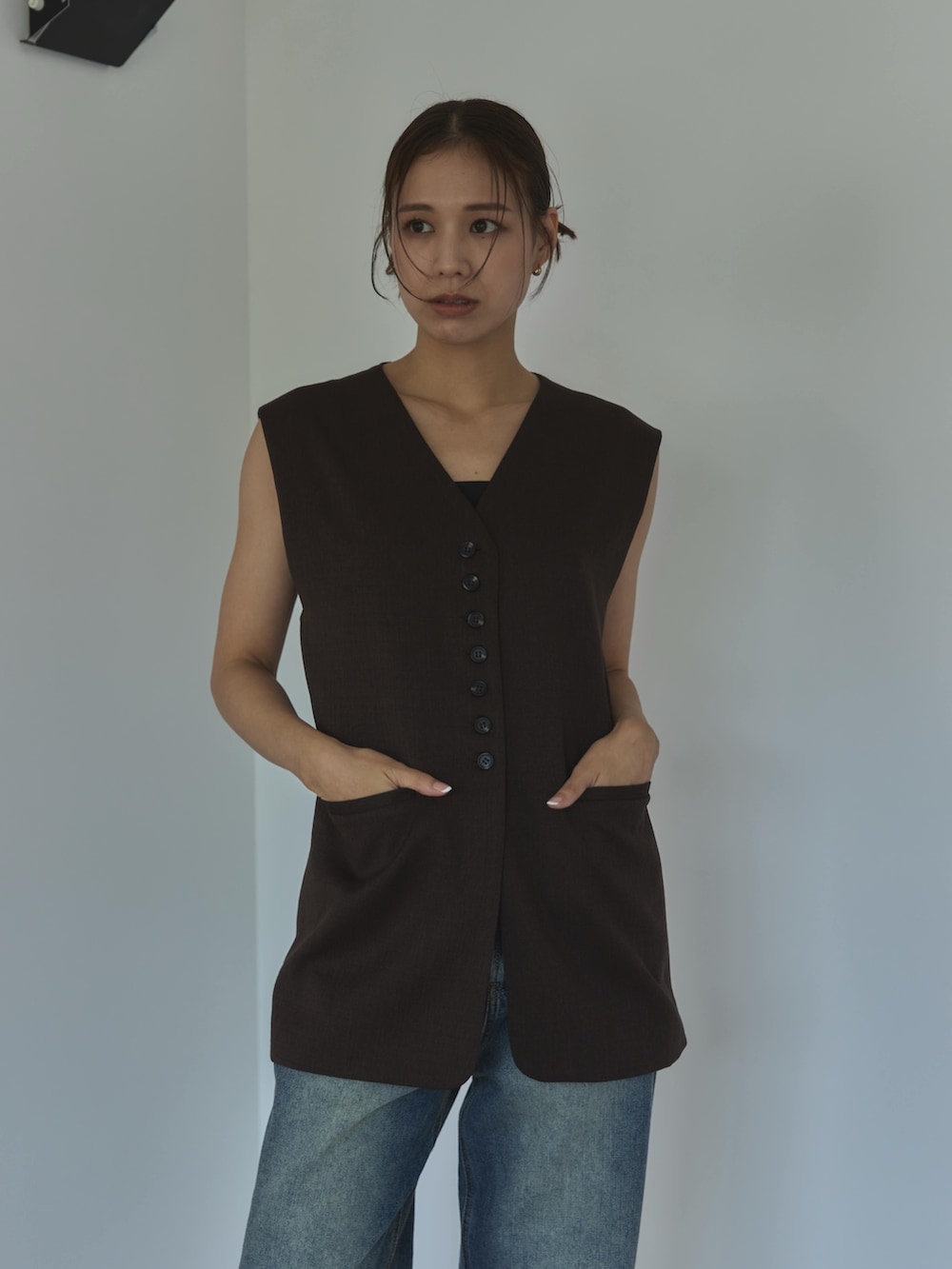 ブラウン系のベスト、ブルー系のデニムパンツ、ベージュ系のサンダルを着用したレディースの夏コーディネートの3枚目の写真