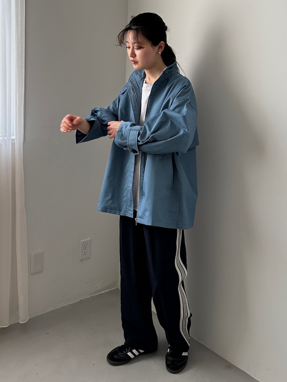 ブルー系のスラックス、ブラック系のスニーカー、ベージュ系のTシャツ/カットソーを着用したレディースの冬コーディネートの2枚目の写真