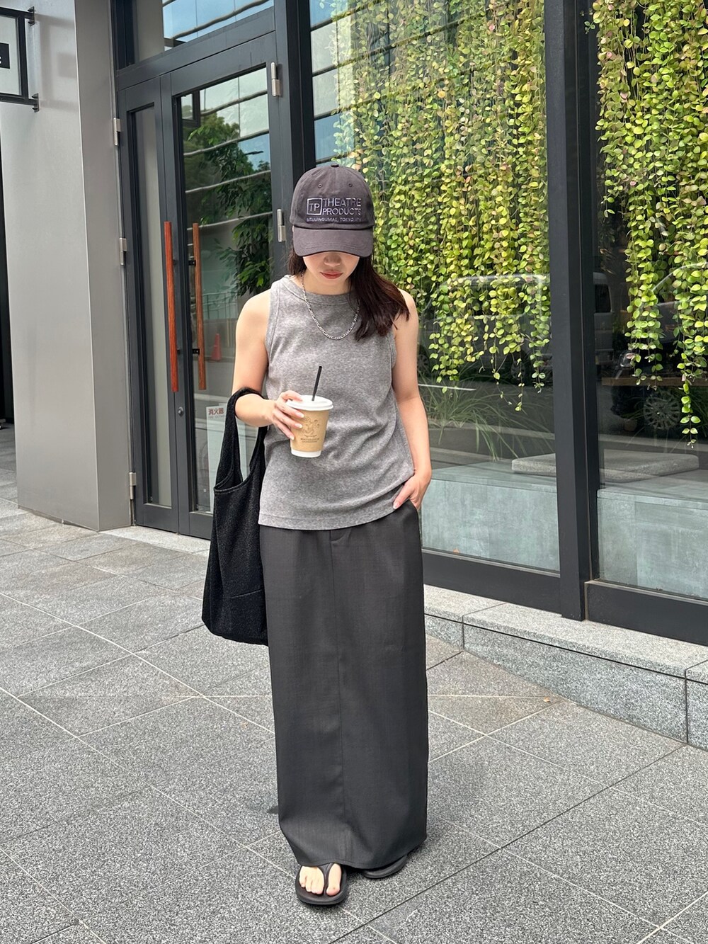 グレー系のタンクトップ、グレー系のスカート、ブラック系のトートバッグを着用したレディースの夏コーディネートの3枚目の写真