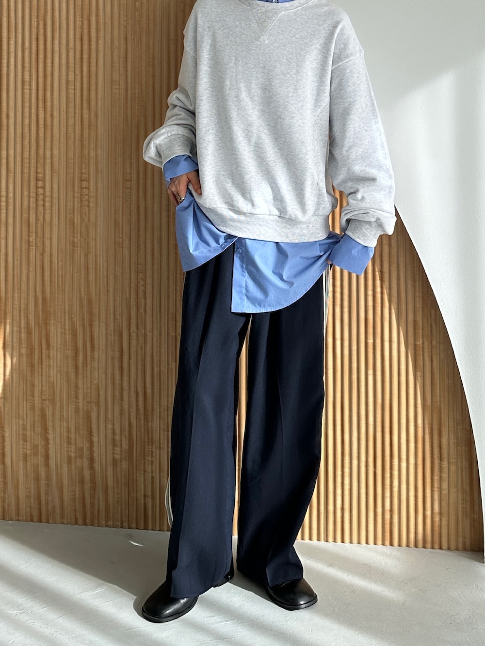 ベージュ系のスウェット、ブルー系のスラックス、ブルー系のシャツ/ブラウスを着用したレディースの秋コーディネートの3枚目の写真