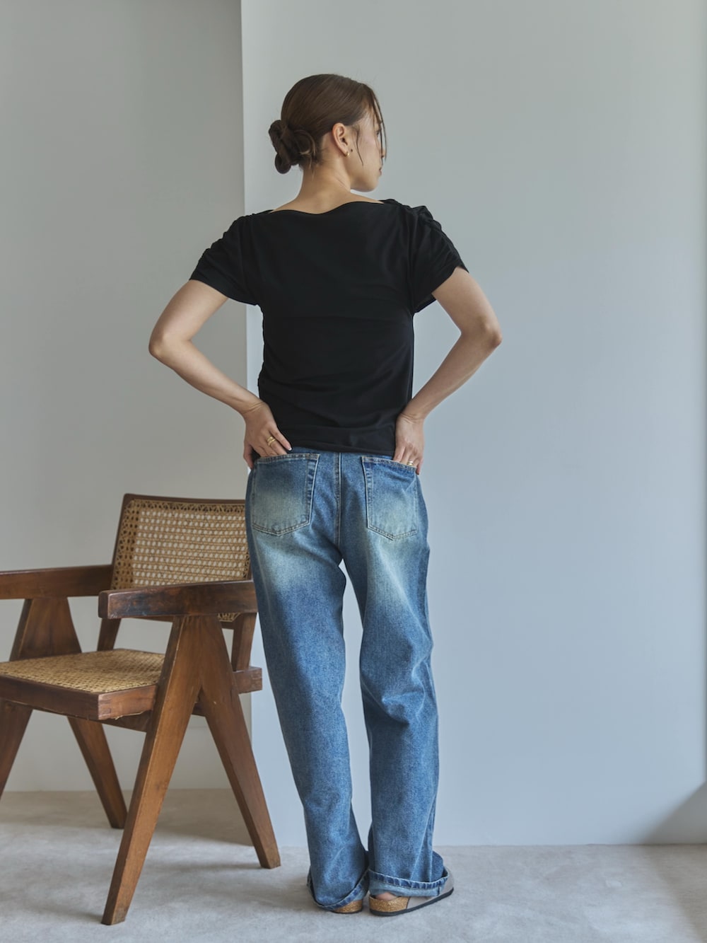 ブラック系のTシャツ/カットソー、ブルー系のデニムパンツ、ベージュ系のサンダルを着用したレディースの夏コーディネートの2枚目の写真