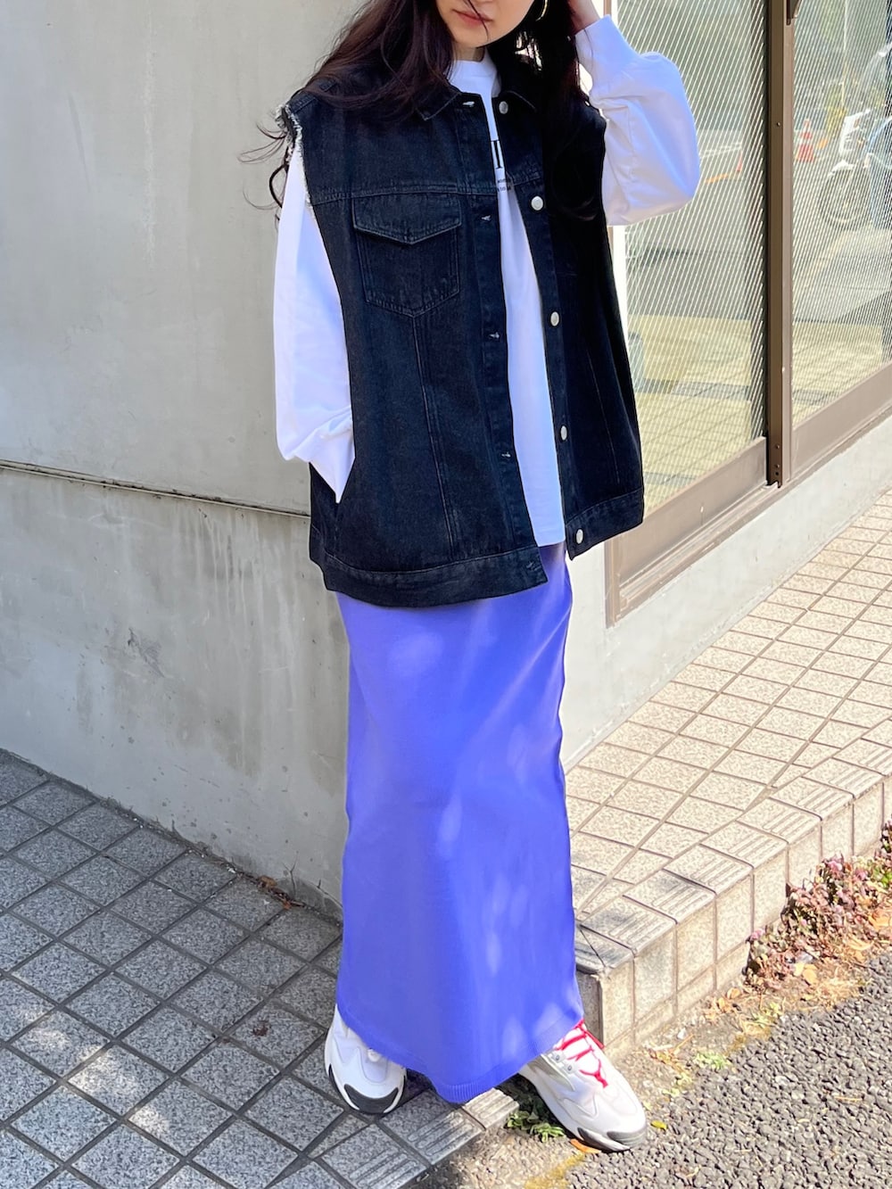 ブラック系のベスト、ホワイト系のスウェット、パープル系のスカートを着用したレディースの春コーディネートの2枚目の写真