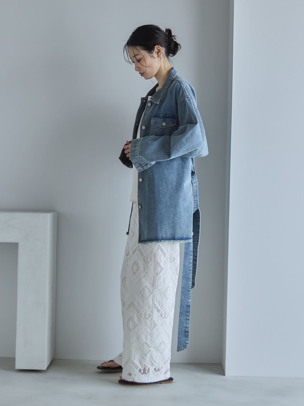 ブルー系のデニムジャケット、ホワイト系のその他パンツ、ブラック系のサンダルを着用したレディースの春コーディネートの2枚目の写真