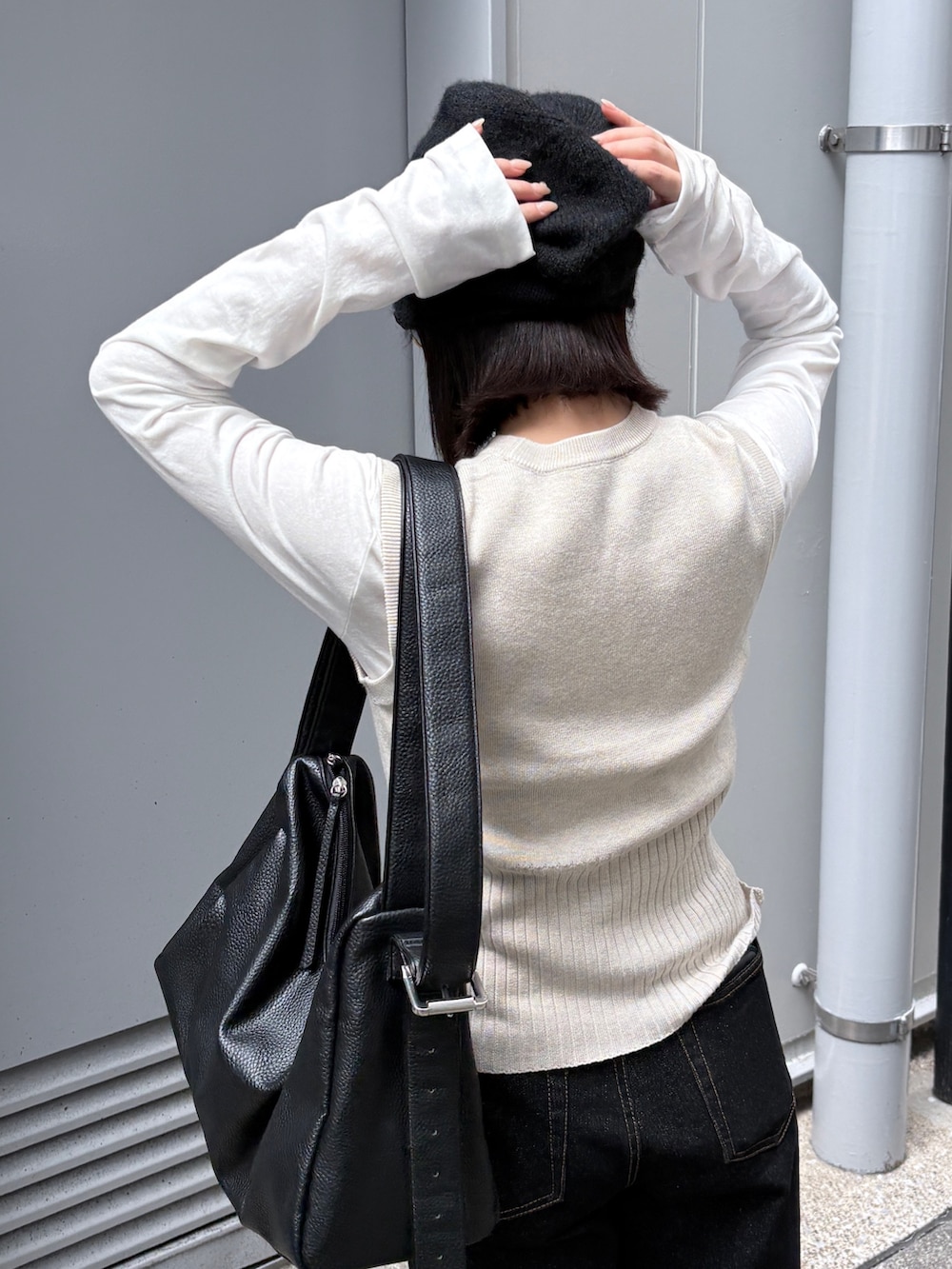 ホワイト系のTシャツ/カットソー、ホワイト系のベスト、ブラック系のデニムパンツを着用したレディースの春コーディネートの5枚目の写真