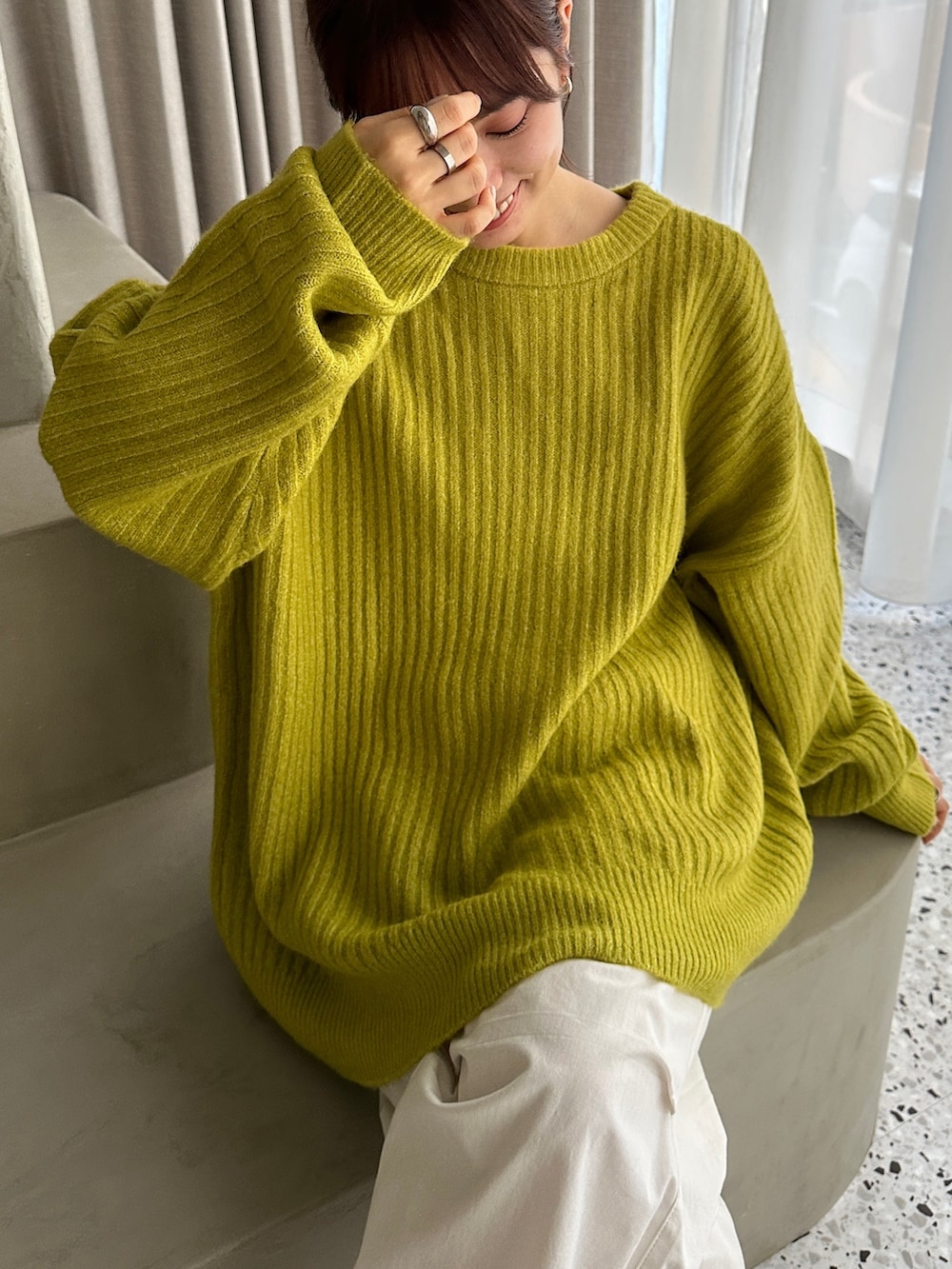 グリーン系のカーディガン/ボレロ、ホワイト系のカーゴパンツ、ホワイト系のスニーカーを着用したレディースの冬コーディネートの3枚目の写真