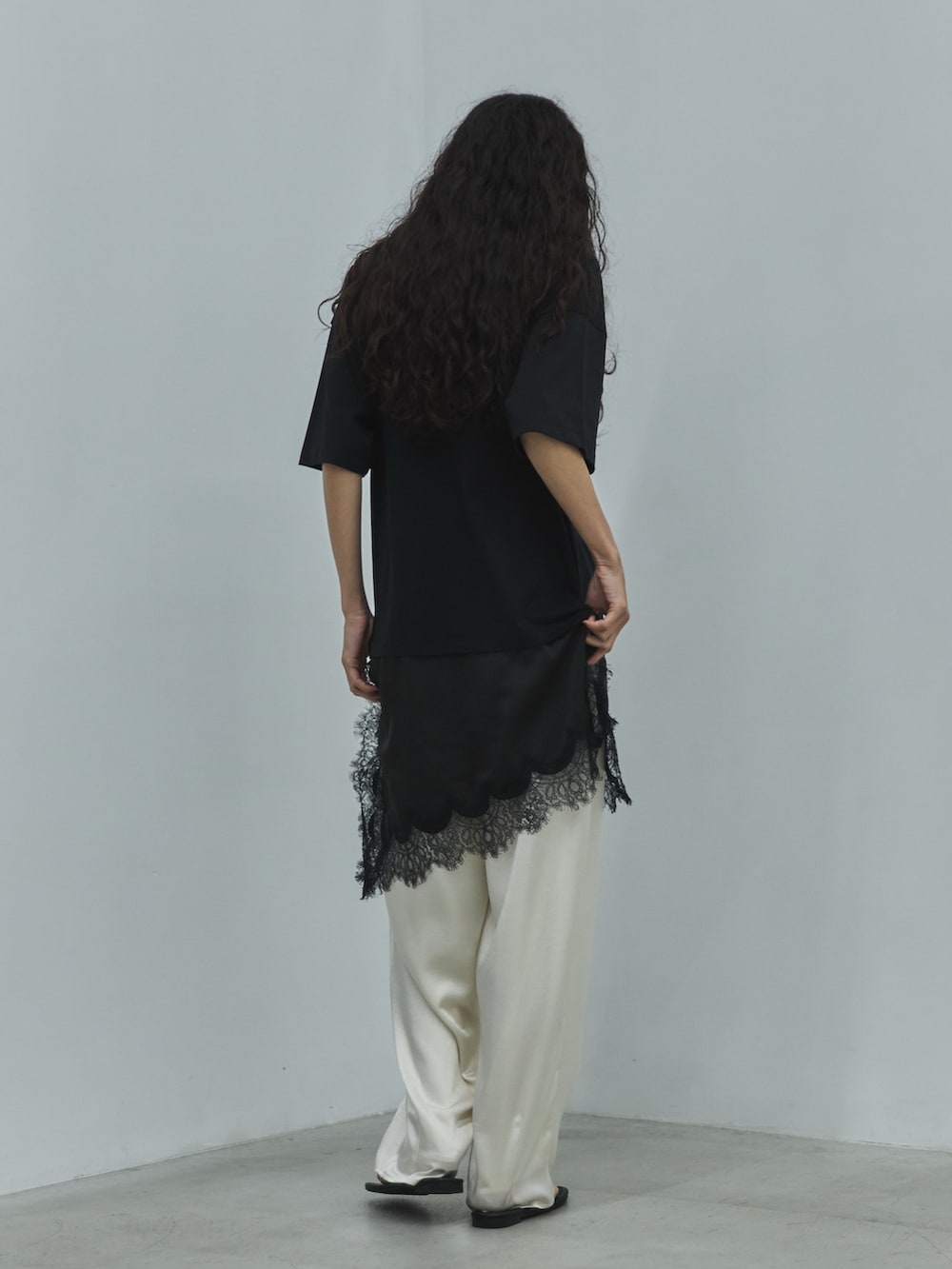 ブラック系のTシャツ/カットソー、ホワイト系のその他パンツ、ブラック系のサンダルを着用したレディースの夏コーディネートの3枚目の写真