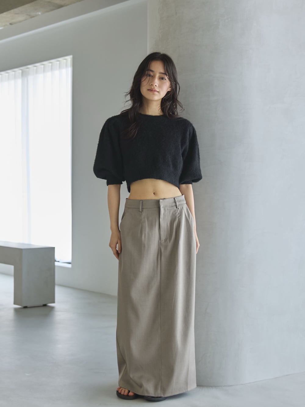 グレー系のスカート、ブラック系のニット/セーター、シルバー系のショルダーバッグを着用したレディースの夏コーディネートの3枚目の写真