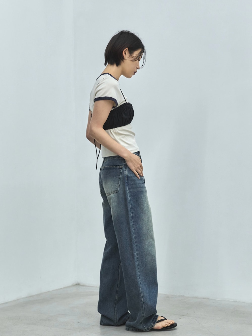 ホワイト系のTシャツ/カットソー、ブラック系のその他トップス、ブルー系のデニムパンツを着用したレディースの夏コーディネートの6枚目の写真
