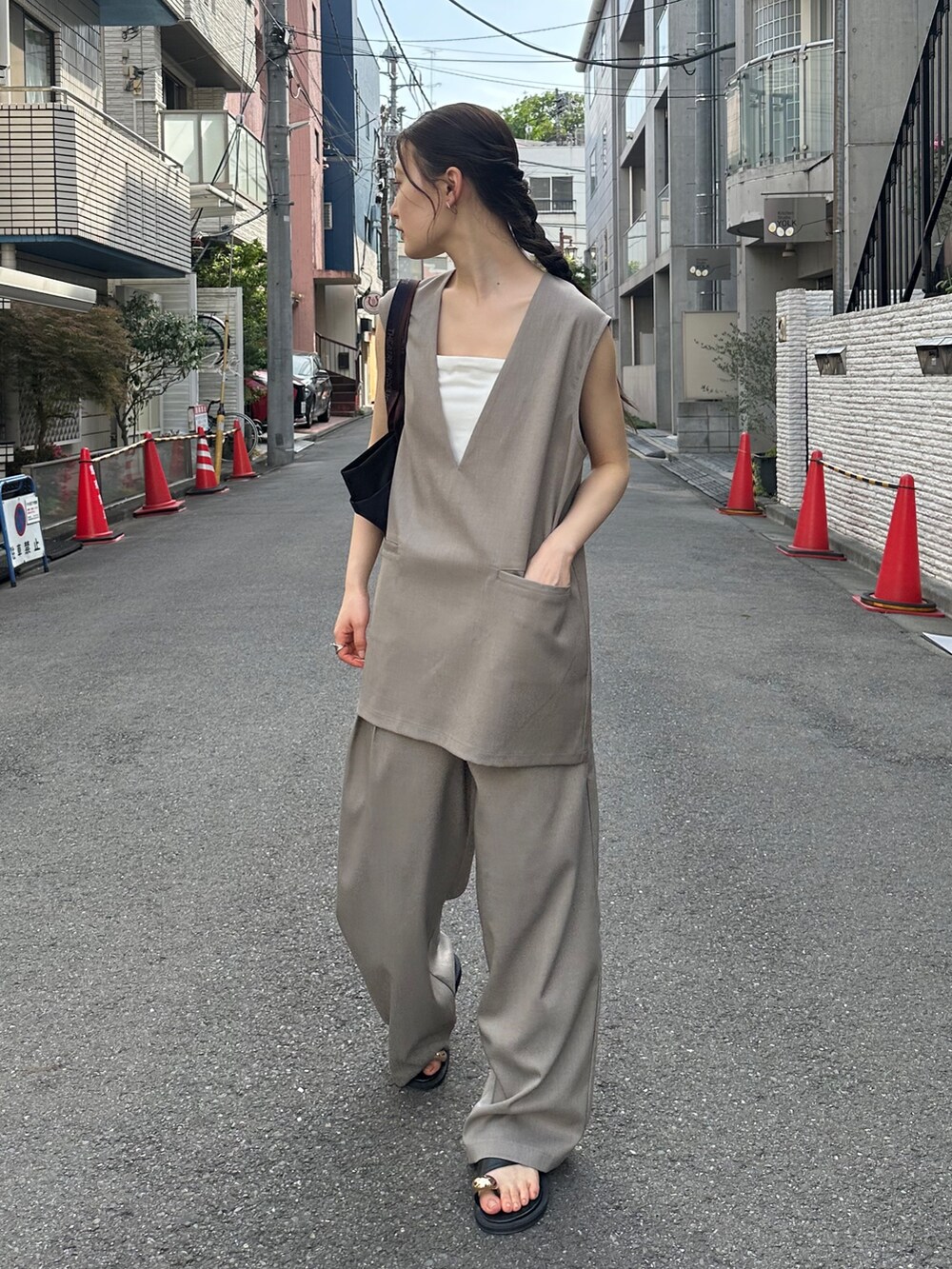 ベージュ系のその他トップス、ベージュ系のスラックス、ブラック系のトートバッグを着用したレディースの夏コーディネートの2枚目の写真