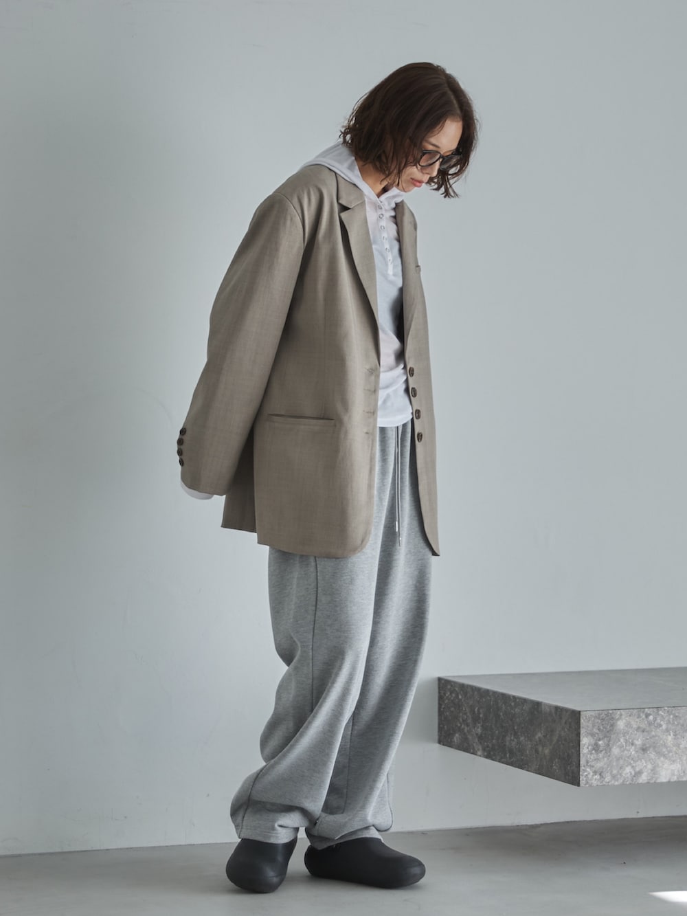 ベージュ系のテーラードジャケット、ホワイト系のTシャツ/カットソー、グレー系のスウェットパンツを着用したレディースの冬コーディネートの2枚目の写真