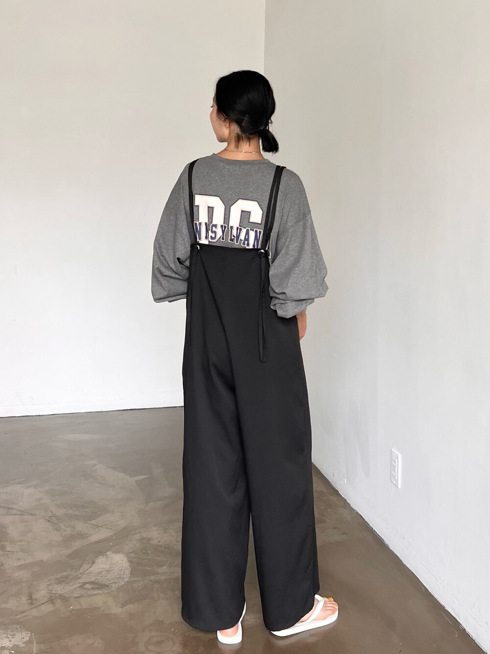 ブラック系のサロペット/オーバーオール、ブラック系のハンドバッグ、グレー系のTシャツ/カットソーを着用したレディースの夏コーディネートの2枚目の写真