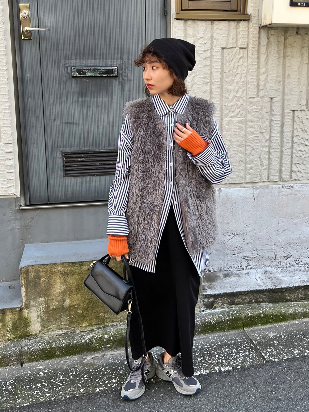 ホワイト系のスラックス、グレー系のベスト、ブルー系のニット/セーターを着用したレディースの秋コーディネートの2枚目の写真