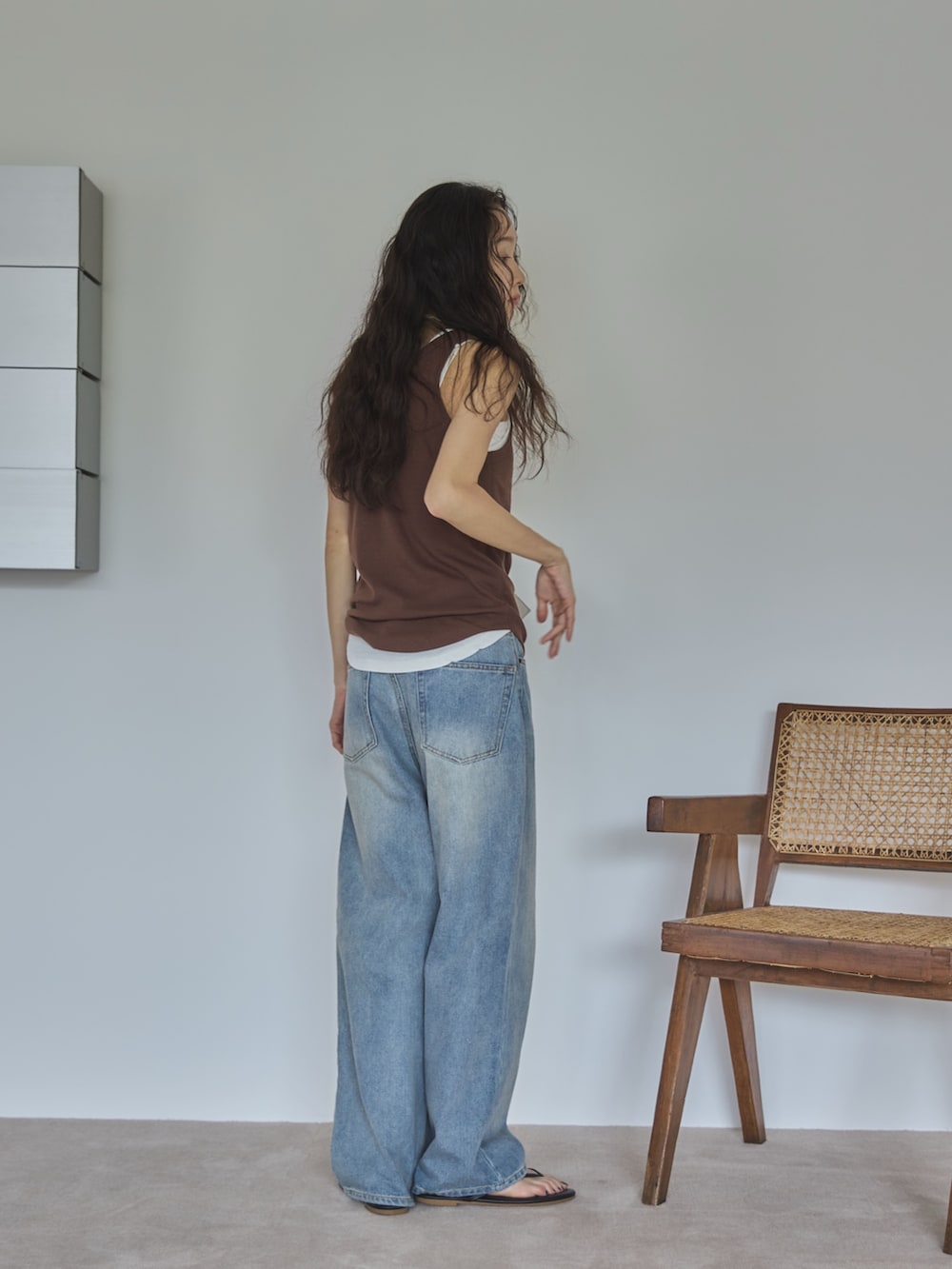 ホワイト系のタンクトップ、ブラウン系のタンクトップ、ブルー系のデニムパンツを着用したレディースの夏コーディネートの2枚目の写真