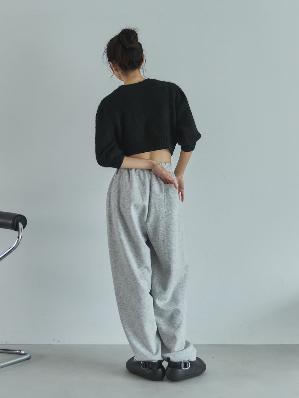 ブラック系のニット/セーター、グレー系のその他パンツ、ブラック系のサンダルを着用したレディースの秋コーディネートの3枚目の写真